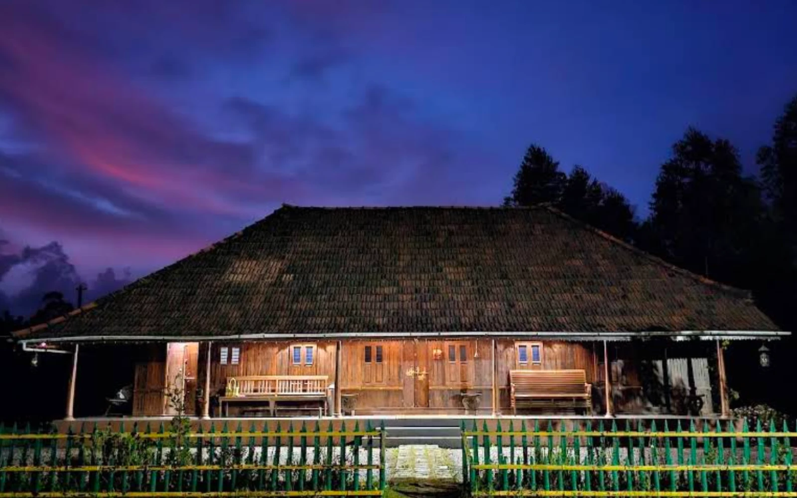 Traditional Kerala timber homestay lit at dusk